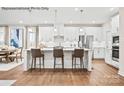 Bright kitchen features white cabinets, stainless appliances, island with seating, and hardwood floors at 1809 Ab Moore Jr Dr # 3238, Indian Trail, NC 28079