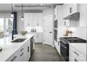 Well-appointed kitchen boasts a large island, modern appliances, white cabinets, and stylish hardware at 1809 Ab Moore Jr Dr # 3238, Indian Trail, NC 28079