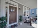 Cozy front porch features stylish seating, a decorative door, and charming details, creating a welcoming entry at 205 Mac Aly, Cramerton, NC 28032