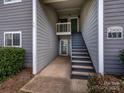 Condo entrance with stairs, gray siding, and well-maintained landscaping, leading to a cozy home at 2900 Heathstead Pl # A, Charlotte, NC 28210