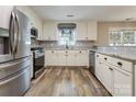 Well-lit kitchen features granite counters, stainless appliances, white cabinets and modern backsplash at 406 Llewellyn St, Belmont, NC 28012
