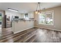 Bright kitchen boasts stainless steel appliances, white cabinetry, and a breakfast bar with pendant lighting at 406 Llewellyn St, Belmont, NC 28012