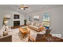 Bright living room with a fireplace, hardwood floors, plush rug, and natural light at 414 Fox Fire Run, Gastonia, NC 28052