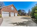 Spacious three-car garage with ample parking space and brick exterior at 4522 Long Cove Dr, Denver, NC 28037