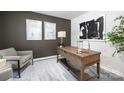 A staged office including stylish desk, lamps, decorative prints and neutral accent chair at 5050 Beargrass Dr, Dallas, NC 28034