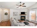 Cozy living room featuring a fireplace, modern ceiling fan, and natural light at 5120 Silabert Ave, Charlotte, NC 28205