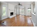 Bright living room features hardwood floors, a painted brick fireplace, large windows, and neutral decor at 7007 Chapparall Ln, Charlotte, NC 28215