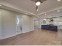 Spacious living area leading to a modern kitchen, with hardwood floors and a seamless design at 908 Davenport St, Charlotte, NC 28208
