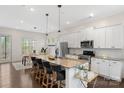 Open kitchen features a large island, modern appliances, and seamless flow into the dining area at 9330 Ainslie Downs St, Charlotte, NC 28273