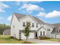 Side view of a two-story home with white siding, stone accents, an attached two-car garage, and a manicured lawn at 149 Saidin Ln, Troutman, NC 28166