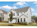 Charming two-story home with white siding, stone accents, a well-manicured lawn, and an attached two-car garage at 149 Saidin Ln, Troutman, NC 28166