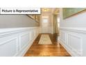 Elegant foyer entrance with hardwood floors, detailed trim work, and a decorative rug at 157 Saidin Ln, Troutman, NC 28166