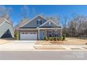 Charming brick home featuring a two-car garage, a light blue door, and beautifully landscaped front yard at 234 Pintail Dr, Monroe, NC 28110