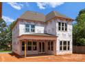 The back of a new construction home shows Tyvek wrap and many windows at 2530 Elkwood Cir, Charlotte, NC 28205