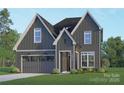 Charming two-story home with gray siding, white trim, garage, manicured lawn, and inviting front entry at 2530 Elkwood Cir, Charlotte, NC 28205