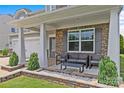 Cozy front porch with seating area, stone accents, columns, and manicured landscaping at 3008 Dundee Ln, Fort Mill, SC 29707
