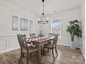 Bright dining room with a wooden table, neutral chairs, modern lighting, and large window at 3038 Lydney Cir, Waxhaw, NC 28173