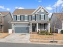 Charming two-story home with blue siding, black shutters, well-manicured lawn, and inviting front porch at 3038 Lydney Cir, Waxhaw, NC 28173
