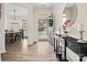 Elegant foyer with wood floors, a modern console table, and a view into the dining room at 3038 Lydney Cir, Waxhaw, NC 28173