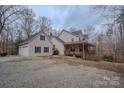 View of home with two car garage and wooden deck, surrounded by mature trees at 369 Falcon Dr, Concord, NC 28025