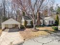 Inviting single-story home with a brick chimney, red shutters, landscaped yard, and detached garage at 457 Birchwood Ne Trl, Concord, NC 28025