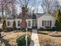 Charming single-story home features a brick chimney, red shutters, and a well-maintained front yard at 457 Birchwood Ne Trl, Concord, NC 28025