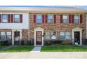 Inviting exterior view of brick townhomes featuring red shutters, well-manicured lawns, and visible unit numbers at 6322 Old Pineville Rd # E, Charlotte, NC 28217