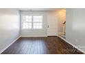 Cozy living room with hardwood floors and a view of the front entrance and staircase at 6322 Old Pineville Rd # E, Charlotte, NC 28217