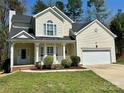 Charming home featuring a well-manicured lawn, cozy front porch, and an attached two-car garage at 10550 Worsley Ln, Charlotte, NC 28269