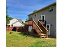 View of the house's backyard, including a new wooden deck and a well-maintained lawn at 115 Scotch Irish Ln, Troutman, NC 28166