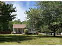 Attractive single-story house surrounded by mature trees and a lush green lawn at 115 Scotch Irish Ln, Troutman, NC 28166