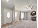 Bright living room featuring a ceiling fan, fireplace with built-in shelves, and a window with curtains at 115 Scotch Irish Ln, Troutman, NC 28166