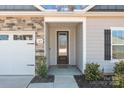 Close up of front entrance featuring a black front door, stone accents, and a manicured lawn at 127 Tradesmen Trl, Troutman, NC 28166