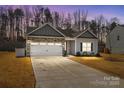 Charming home featuring a stone and vinyl exterior, two-car garage, and well-manicured lawn at 127 Tradesmen Trl, Troutman, NC 28166