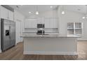 Bright kitchen with stainless steel appliances, granite countertops and white cabinets at 127 Tradesmen Trl, Troutman, NC 28166