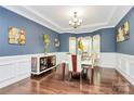 Formal dining room features elegant lighting, wainscoting, and ample space for entertaining at 14125 Derby Farm Ln, Charlotte, NC 28278