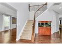 Bright foyer with hardwood floors, staircase with metal spindles, and fish tank at 14125 Derby Farm Ln, Charlotte, NC 28278