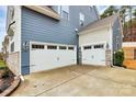 Spacious three-car garage offers ample parking and storage with well lit exterior wall fixtures at 14125 Derby Farm Ln, Charlotte, NC 28278