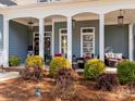 Inviting front porch adorned with decorative wreaths, cozy seating, and elegant pendant lighting at 1742 Verdict Ridge Dr, Denver, NC 28037