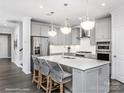 Bright kitchen featuring a large center island with seating, stainless steel appliances, and pendant lighting at 1914 Sparkling Stream Dr # 057, Belmont, NC 28012