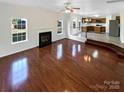 Bright living room with hardwood floors and a fireplace, seamlessly connecting to the kitchen through an open-concept design at 215 Madelia Pl, Mooresville, NC 28115