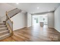 Spacious open-concept living area with hardwood floors and abundant natural light, next to stairs at 2280 Hedgecliff Rd, Kannapolis, NC 28025