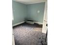 A view of a quiet bedroom with light blue walls, neutral carpet, and window allowing natural light at 2404 Booker Ave, Charlotte, NC 28216
