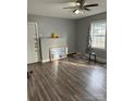 Bright living room featuring wood-look floors, neutral walls, natural light, and a modern ceiling fan at 2404 Booker Ave, Charlotte, NC 28216