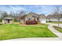 Well-maintained home showcasing lush greenery, a storage shed, and a brick facade at 258 Lagoda Dr, Locust, NC 28097