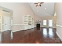 Bright living room with wood floors, vaulted ceiling, fireplace, and custom built-in shelving at 258 Lagoda Dr, Locust, NC 28097