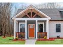 Close up of the home's charming craftsman-style front porch and orange front door at 2853 W Zion Church Rd, Shelby, NC 28150