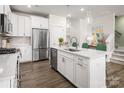 Bright kitchen with stainless steel appliances, white cabinetry, an island, and wood floors at 3020 Finchborough Ct # 230, Charlotte, NC 28269