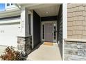 Welcoming front porch with stone accents and neutral-colored door at 416 Clemson Tree Ln, Lake Wylie, SC 29710