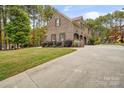 Charming brick home with a long driveway, landscaped yard, and three-car garage at 472 Barber Loop, Mooresville, NC 28117